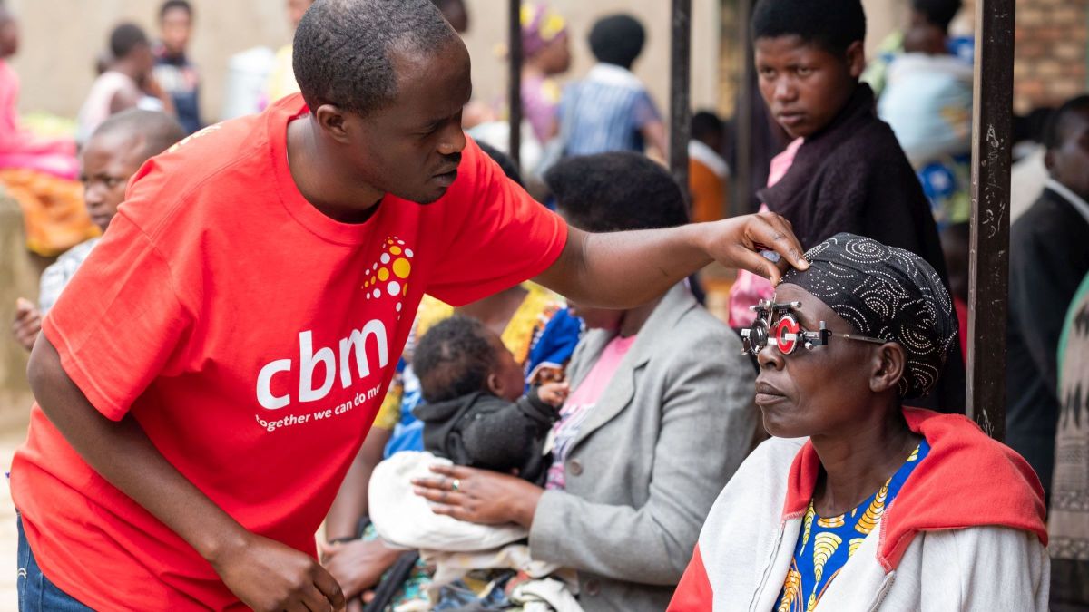 Ein Mann untersucht die Augen einer Frau mit Refaktionsbrille
