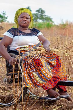 A woman in a wheel chair in dry field