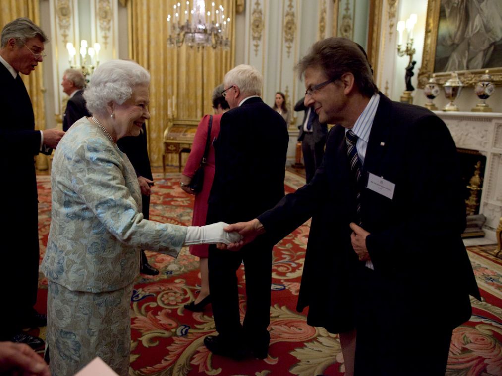 A man greeting the queen in the palace.