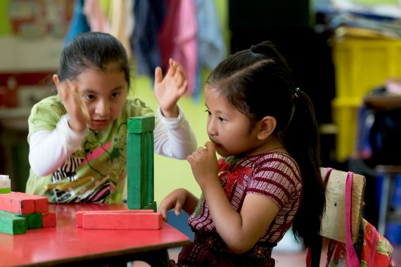 Two girls playing with colourful blocks