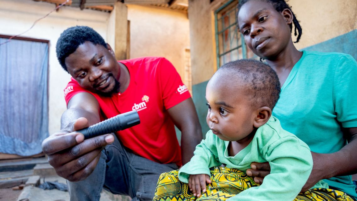 A man is shining in a babys eye