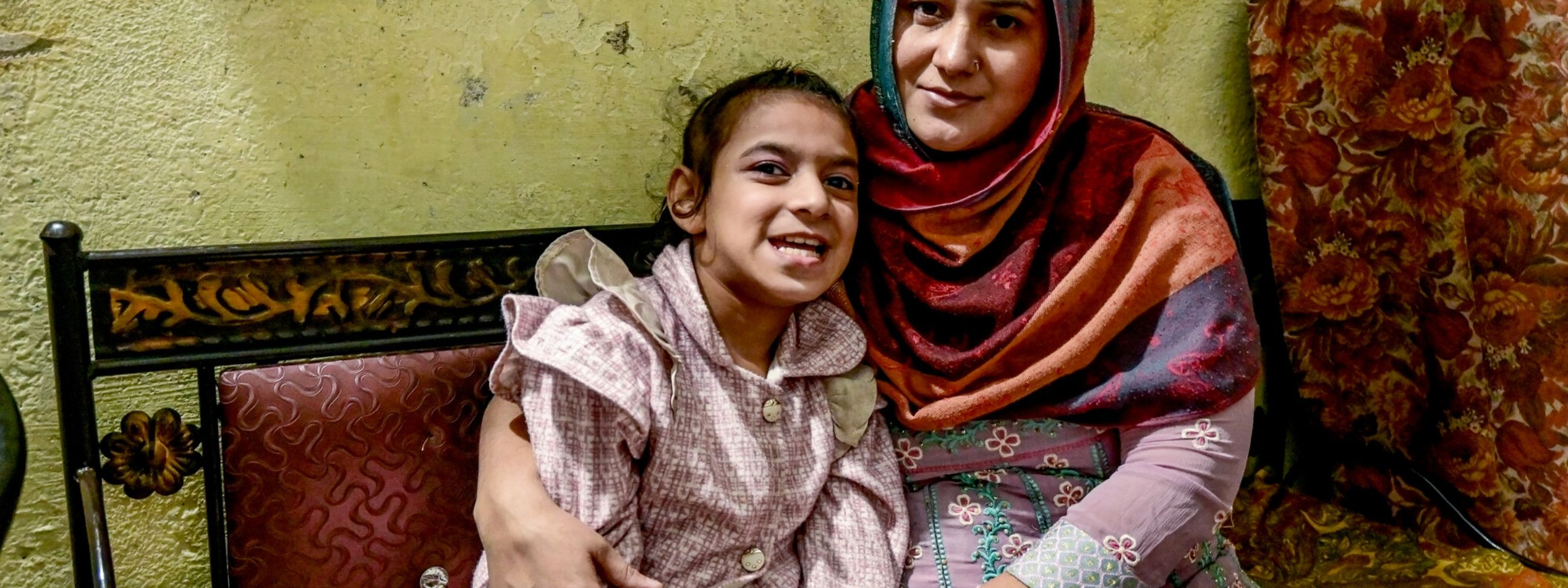 A mother and her intellectual and physical disabled daughter sitting on a bench