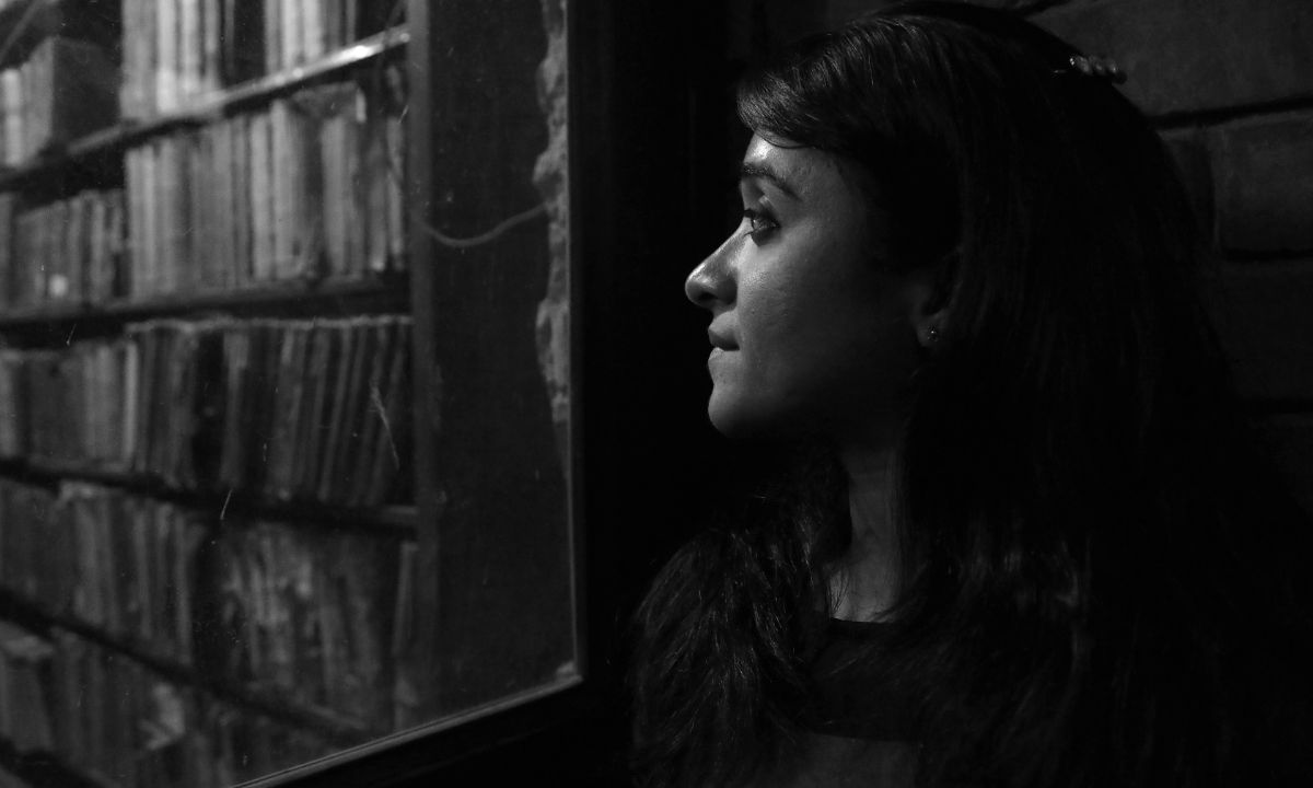 Eine junge Frau schaut aus einem Fenster