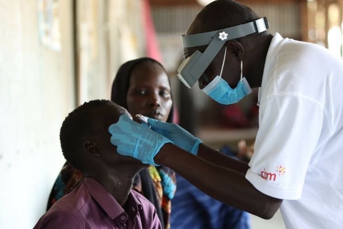 A doctor is treating a boy in Africa